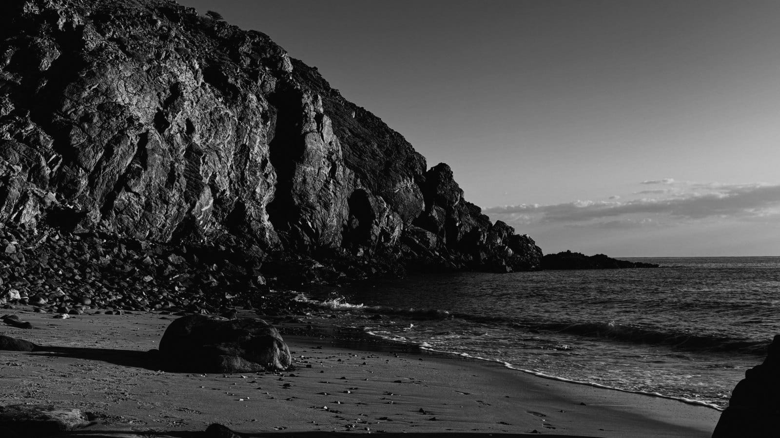 A rocky cove and beach in black and white