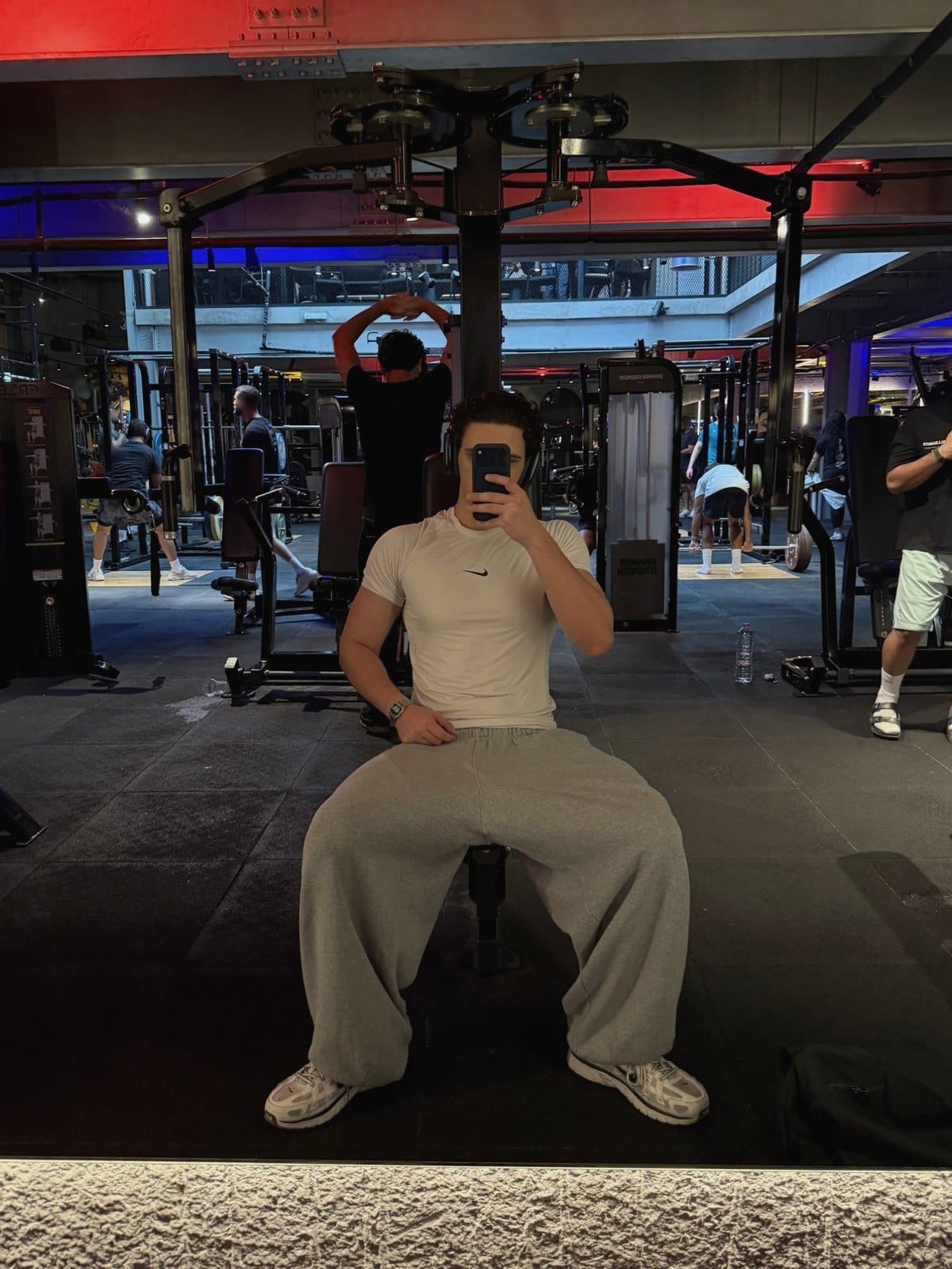 Mirror selfie in a gym, phone covering the face