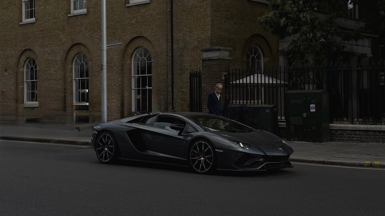 A dark grey Lamborghini on a London street