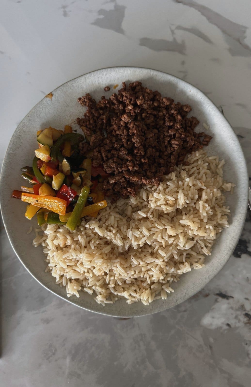 A plate of rice, spiced mince and roasted peppers